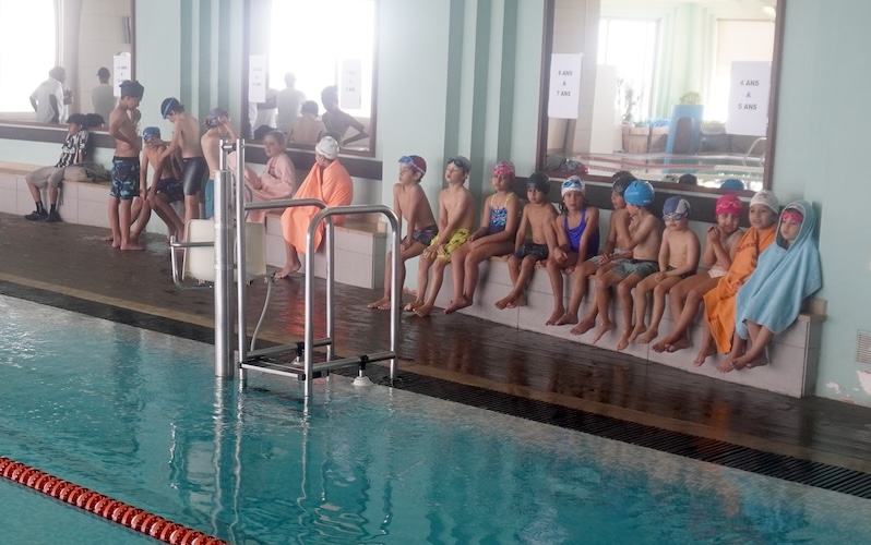 A kids' swim lesson at the edge of the pool